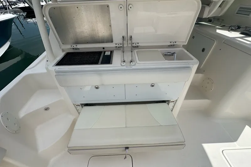 Slide: The Image of 2013 Pursuit OS 345 Offshore boat galley with sink and storage compartments. - 29