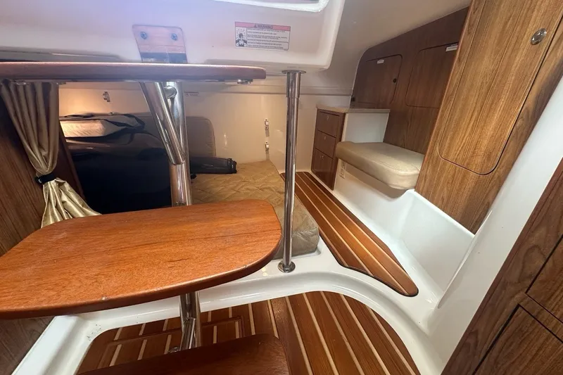 Slide: The Image of 2013 Pursuit OS 345 Offshore cabin interior with wood accents and seating area. - 16