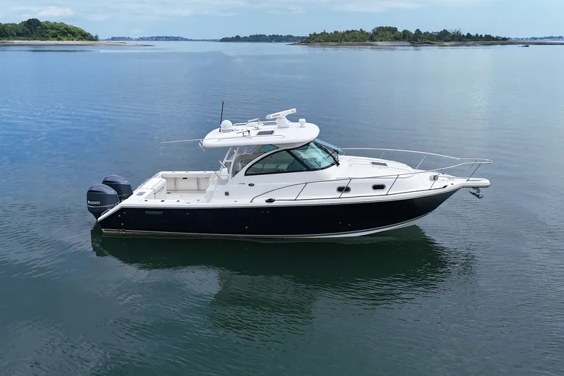 The Image of 2013 Pursuit OS 345 Offshore boat on calm water, showcasing sleek design and twin engines. - 0