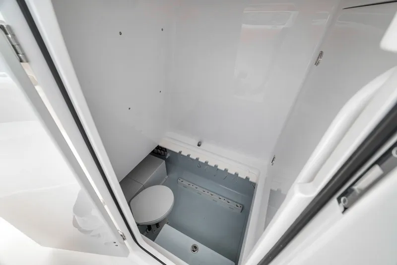Slide: The Image of Interior of a 2020 Bahama 41 boat bathroom, featuring a compact toilet and sleek design. - 32