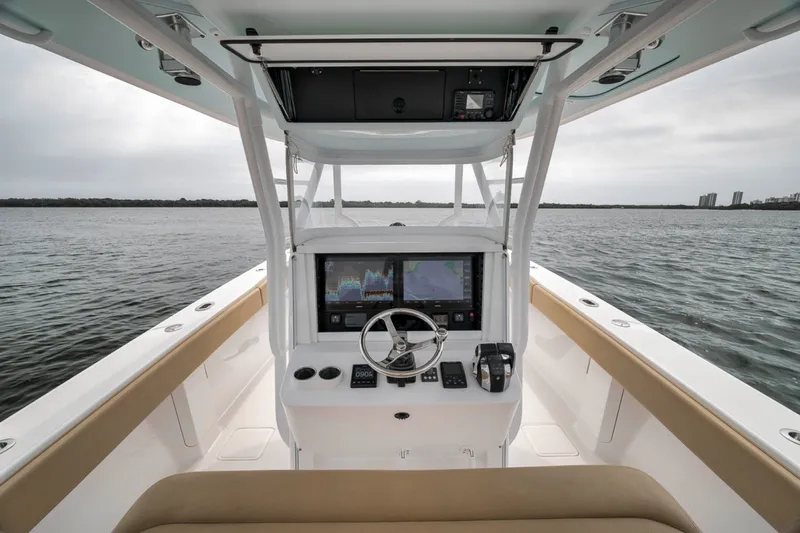 Slide: The Image of 2020 Bahama 41 boat helm with navigation screens on calm water. - 28