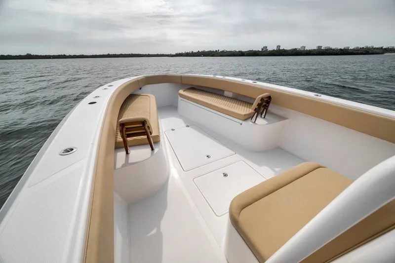 Slide: The Image of 2020 Bahama 41 boat interior with tan seating on calm water. - 17