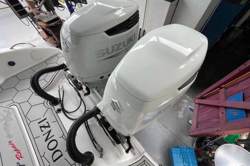 Slide: The Image of 1998 Donzi 29 ZF Cuddy with twin Suzuki outboard motors in a garage setting. - 56