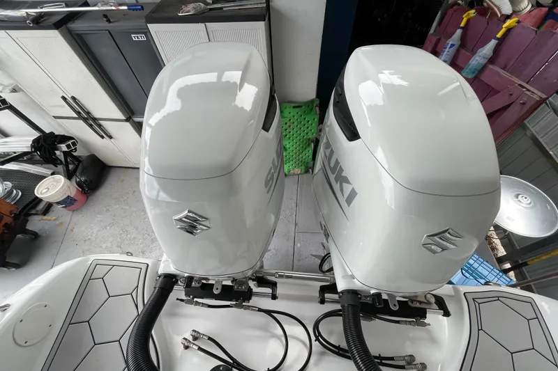 Slide: The Image of Twin Suzuki outboard engines on a 1998 Donzi 29 ZF Cuddy boat in a garage. - 55