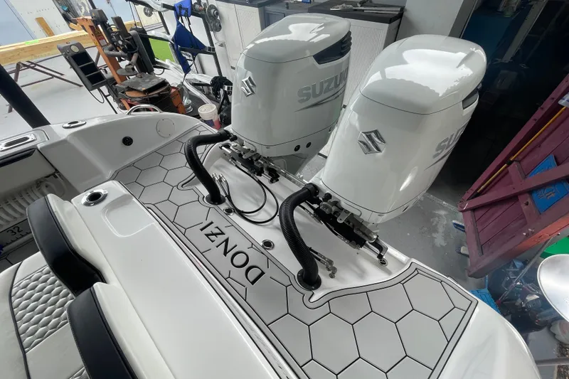 Slide: The Image of 1998 Donzi 29 ZF Cuddy boat with twin Suzuki outboard engines in a workshop setting. - 29
