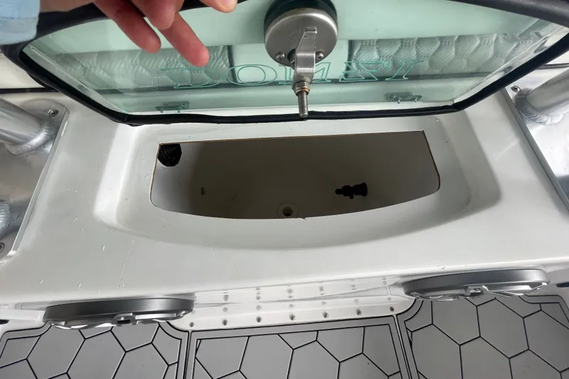 Slide: The Image of 1998 Donzi 29 ZF Cuddy boat interior, featuring storage compartment and hexagonal patterned flooring. - 34