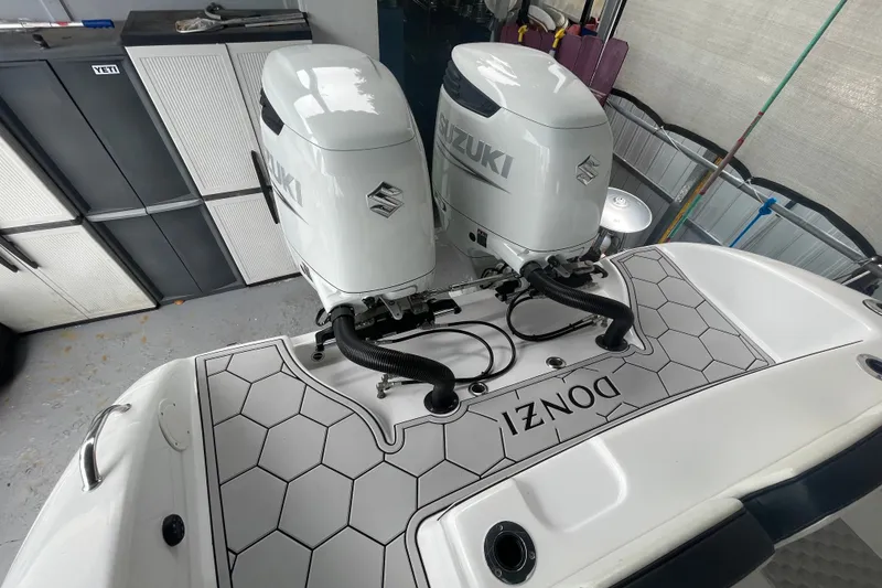 Slide: The Image of 1998 Donzi 29 ZF Cuddy with twin Suzuki outboard engines in a garage. - 27