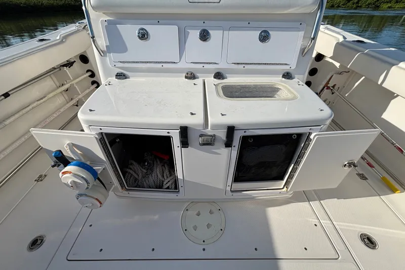 Slide: The Image of 2014 Robalo R300 Center Console boat with open storage compartments and fishing gear. - 28