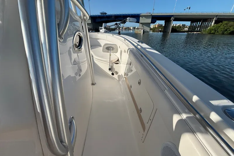 Slide: The Image of 2014 Robalo R300 Center Console boat docked near a bridge on calm water. - 29
