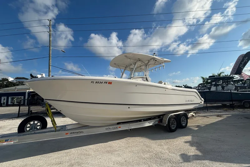 Slide: The Image of 2014 Robalo R300 Center Console boat on trailer under blue sky. - 0