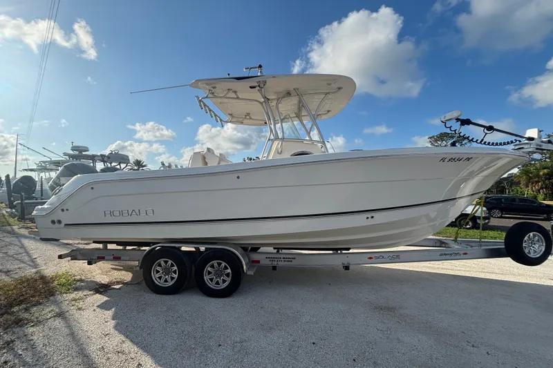 Slide: The Image of 2014 Robalo R300 Center Console boat on trailer under blue sky. - 33