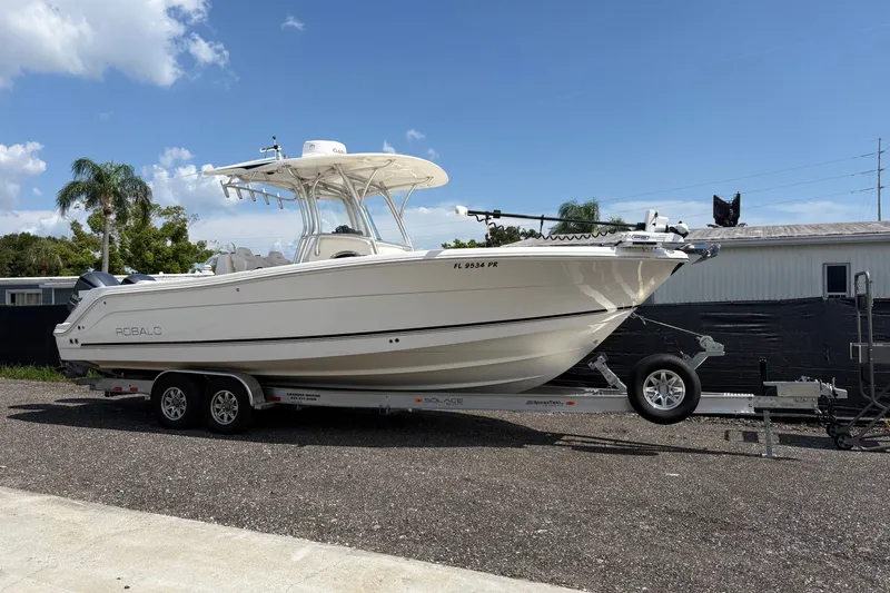 The Image of 2014 Robalo R300 Center Console boat on trailer under clear blue sky. - 1