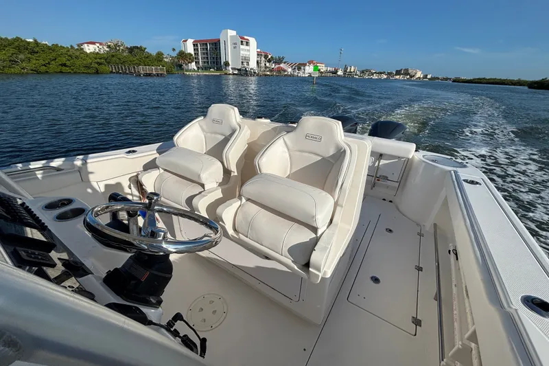 Slide: The Image of 2014 Robalo R300 Center Console boat interior with dual seats on open water. - 22