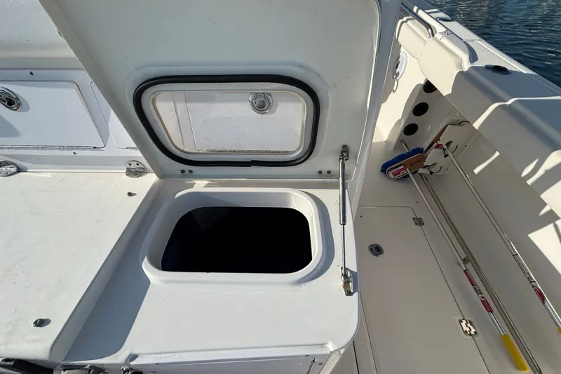 Slide: The Image of 2014 Robalo R300 Center Console boat storage compartment open on deck. - 18
