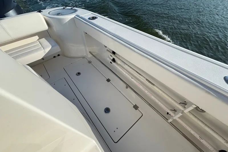 Slide: The Image of 2014 Robalo R300 Center Console boat interior with seating and storage, on water. - 9