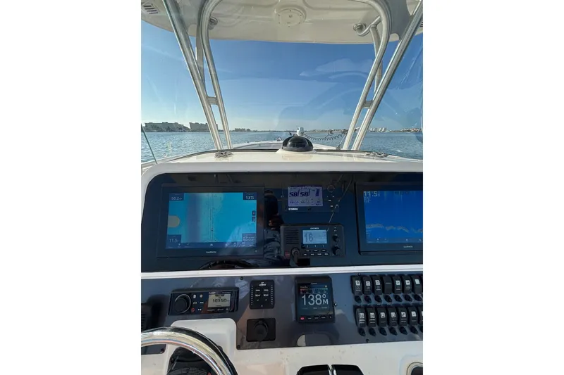 Slide: The Image of 2014 Robalo R300 Center Console boat dashboard with navigation screens and controls. - 10