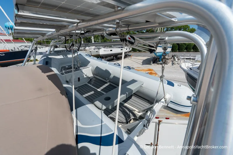 Slide: The Image of 2016 Jeanneau Sun Odyssey 439 sailboat with dinghy on deck, docked at a marina. - 35