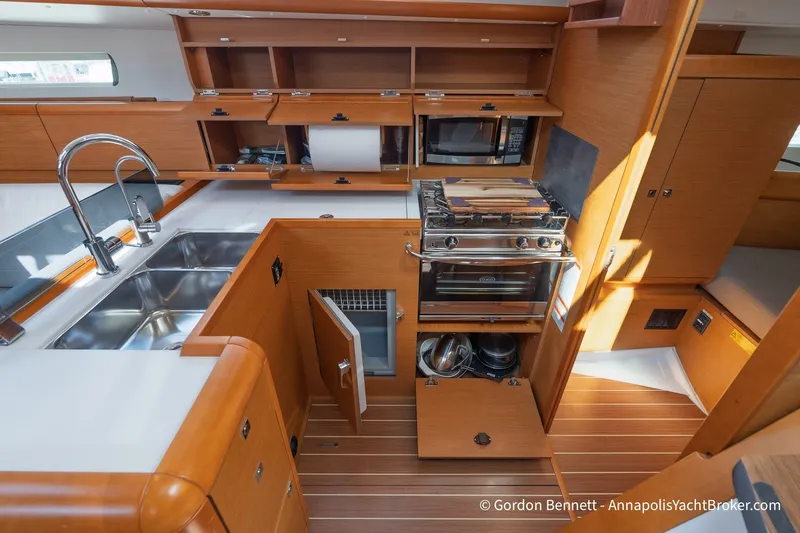 Slide: The Image of Interior of 2016 Jeanneau Sun Odyssey 439 yacht kitchen with modern appliances and wooden cabinetry. - 50