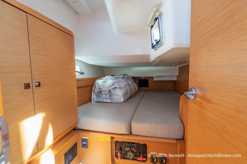 Slide: The Image of Interior cabin of 2016 Jeanneau Sun Odyssey 439 yacht, featuring cozy bedding and wooden cabinetry. - 63
