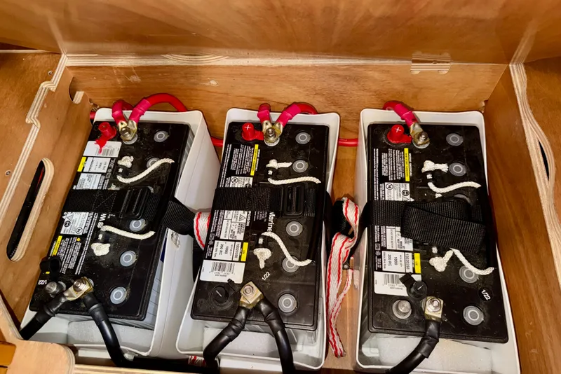 Slide: The Image of Three marine batteries in a Jeanneau Sun Odyssey 439, 2016 model, secured with straps. - 69