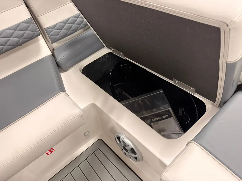 Slide: The Image of The image shows the seating area of a Starcraft 211SVXIO boat with an open storage compartment. - 17