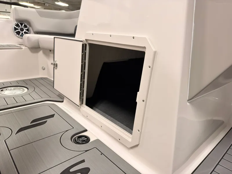 Slide: The Image of The image shows the storage compartment of a 2027 Starcraft 211SVXIO boat with gray flooring. - 30