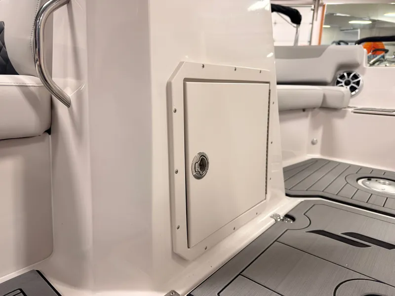 Slide: The Image of The image shows the interior of a 2027 Starcraft 211SVXIO boat with gray flooring. - 31
