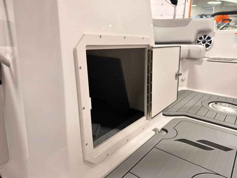 Slide: The Image of An open storage compartment on a boat with gray flooring and cushioned seating. - 32