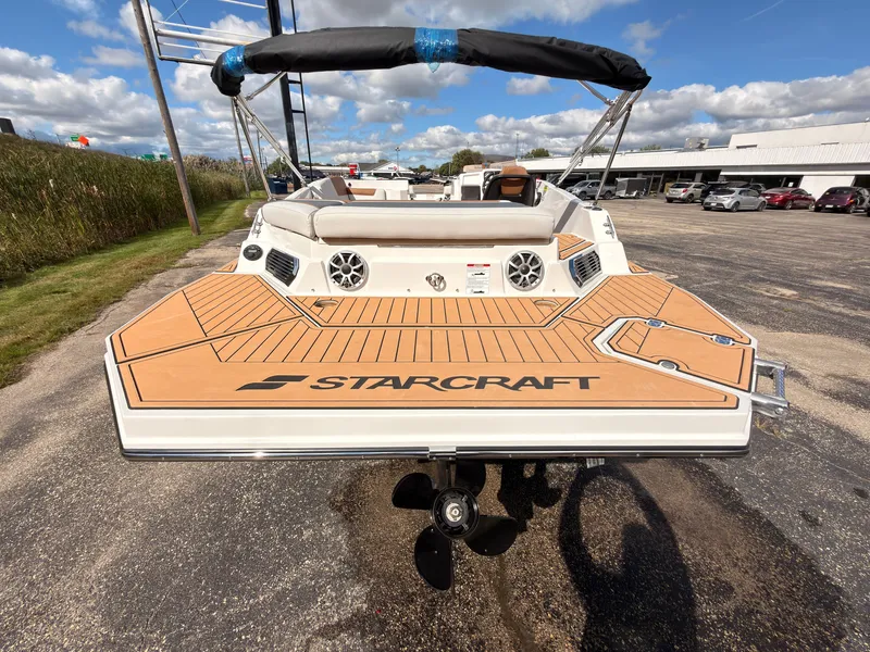 Slide: The Image of The image shows the rear of a 2027 Starcraft 211SVXIO boat with a spacious deck and speakers. - 12
