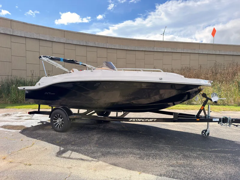 Slide: The Image of A 2027 Starcraft 211SVXIO boat on a trailer in a parking lot. - 1