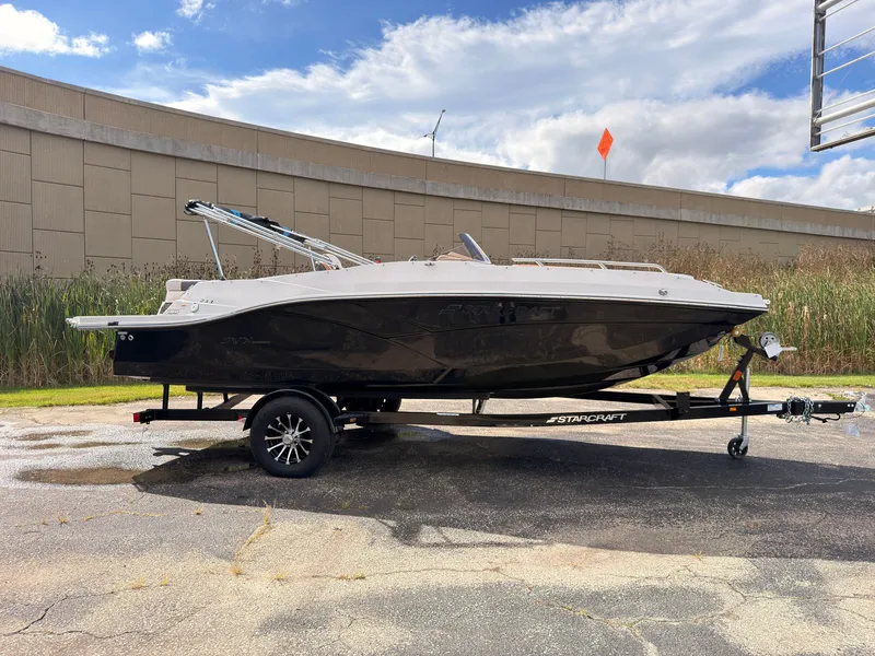 The Image of A 2027 Starcraft 211SVXIO boat on a trailer in front of a building. - 0
