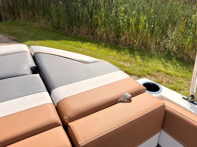 Slide: The Image of The image shows the upholstery of a 2027 Starcraft 211SVXIO boat with brown and gray seating. - 26