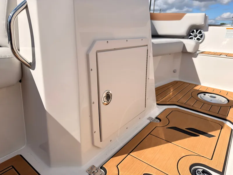 Slide: The Image of The image shows the cockpit of a Starcraft 211SVXIO boat with wood flooring and beige seating. - 48