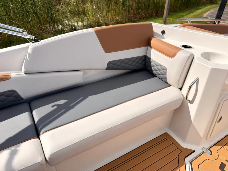 Slide: The Image of The 2027 Starcraft 211SVXIO features a sleek bench seat with gray and brown upholstery. - 33