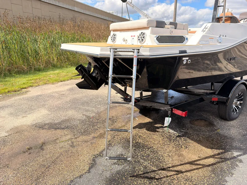 Slide: The Image of The image shows a 2027 Starcraft 211SVXIO boat on a trailer. It features a swim ladder at the stern. - 10