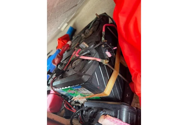 Slide: The Image of Battery compartment of a 2019 Carolina Skiff 24 DLX with cables and straps. - 21
