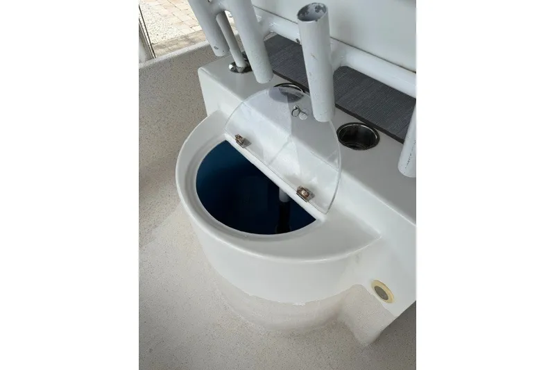 Slide: The Image of Livewell on a 2019 Carolina Skiff 24 DLX boat, featuring rod holders and cup holder. - 12
