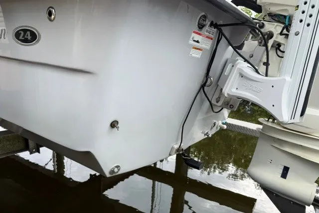Slide: The Image of 2019 Carolina Skiff 24 DLX boat stern view, featuring motor and hull details. - 17