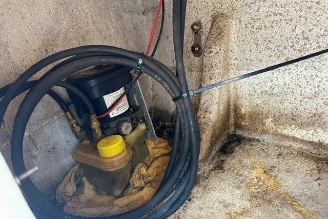 Slide: The Image of Hydraulic system in a 2019 Carolina Skiff 24 DLX boat, featuring cables and fluid reservoir. - 19