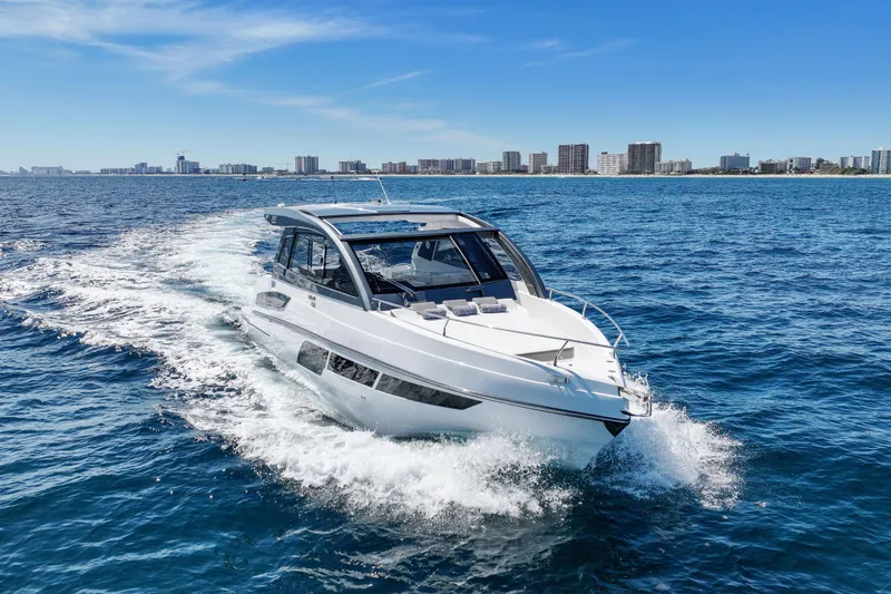 Slide: The Image of 2025 VALIATT YACHTS 380 Bowrider cruising on open water near city skyline. - 5