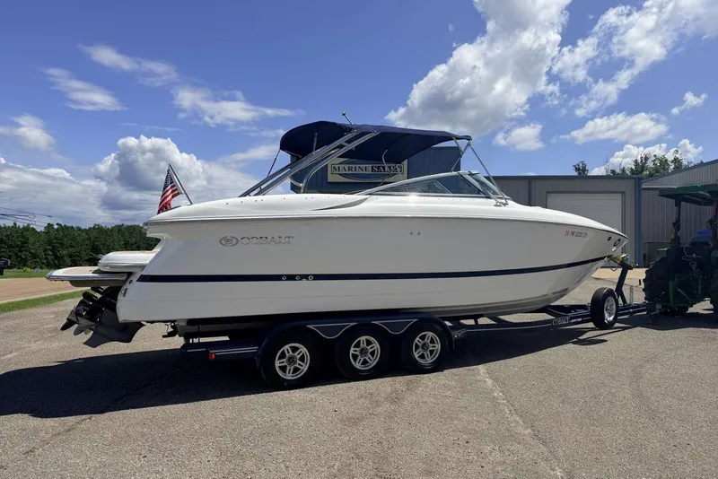 The Image of 2008 Cobalt 282 boat on trailer, parked outdoors under a blue sky. - 1