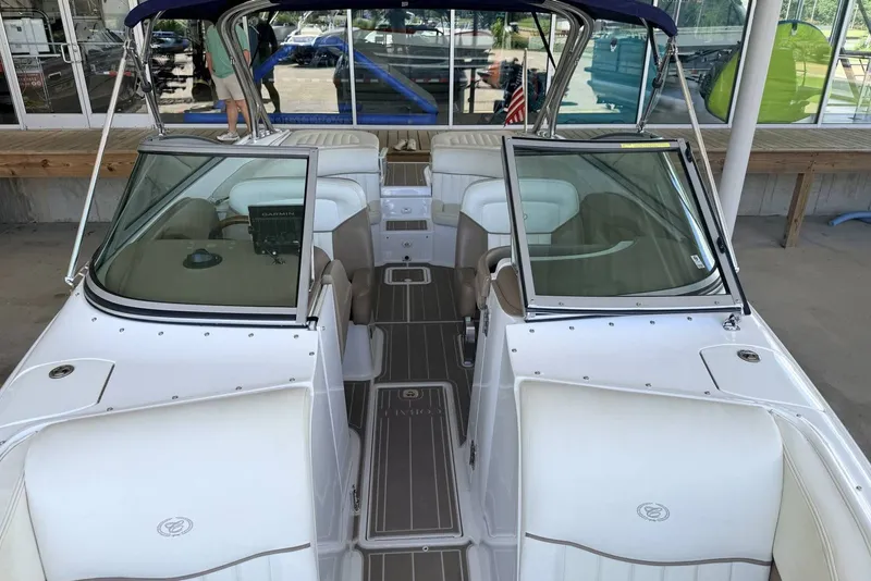 Slide: The Image of 2008 Cobalt 282 boat interior with seating and dashboard, docked at a marina. - 24