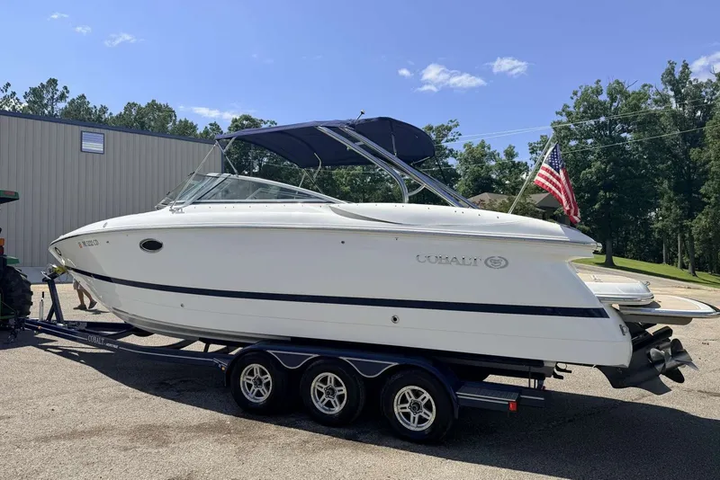Slide: The Image of 2008 Cobalt 282 boat on trailer, American flag, sunny day, trees in background. - 6