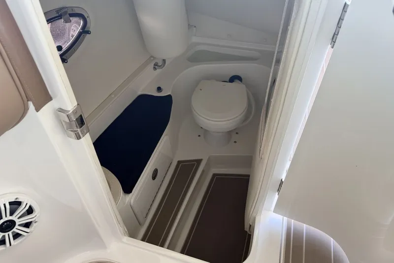 Slide: The Image of Interior of a 2008 Cobalt 282 boat featuring a compact marine toilet. - 17