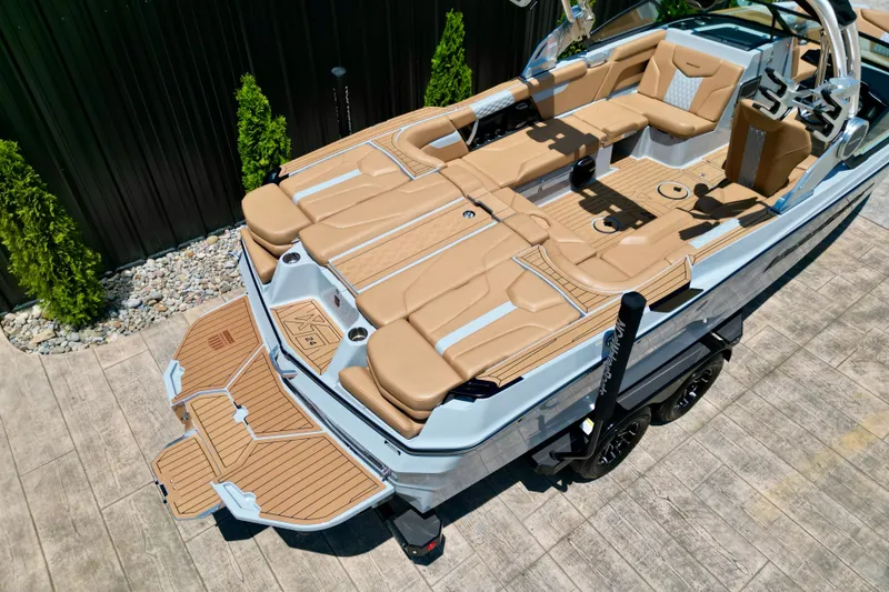 Slide: The Image of 2026 MasterCraft XT24 boat with tan seating and sleek design on a trailer. - 22