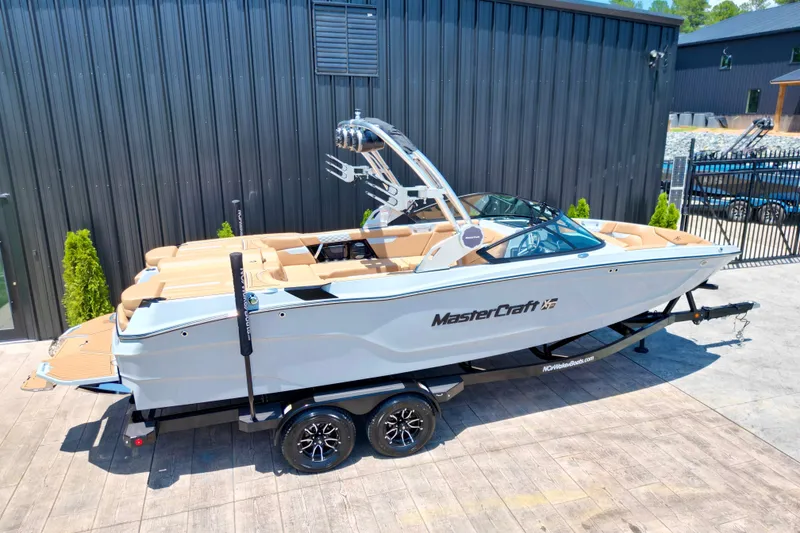Slide: The Image of 2026 MasterCraft XT24 boat on trailer, sleek design, parked outdoors. - 3