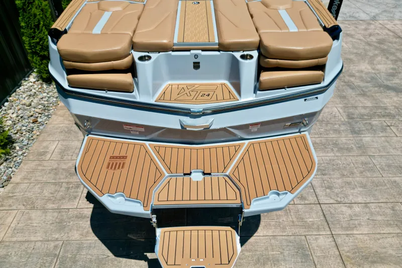 Slide: The Image of 2026 MasterCraft XT24 boat with tan seating and teak-style swim platform. - 4