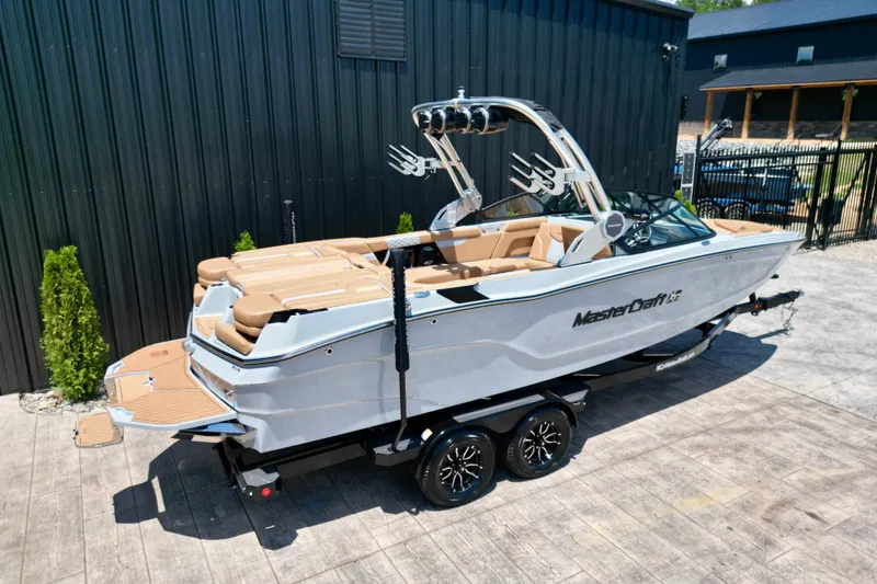 Slide: The Image of 2026 MasterCraft XT24 boat on trailer, sleek design, parked outdoors. - 23