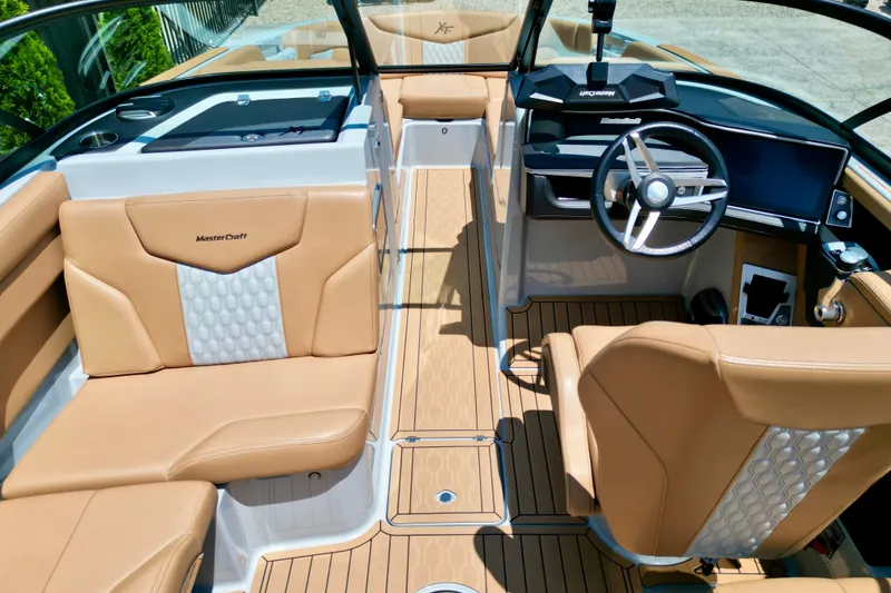 Slide: The Image of 2026 MasterCraft XT24 boat interior with tan leather seats and modern dashboard. - 9