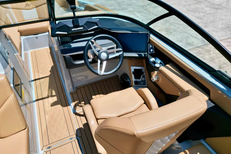 Slide: The Image of 2026 MasterCraft XT24 boat interior with modern dashboard and tan leather seating. - 7